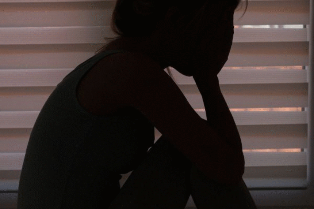 Woman Sitting in Silence Holding Her Face – Emotional Pain and Trauma Reflection