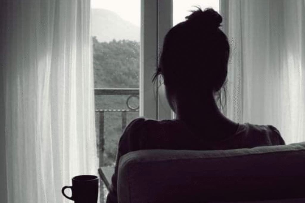 Woman Sitting Alone by a Window – Quiet Reflection and Emotional Healing